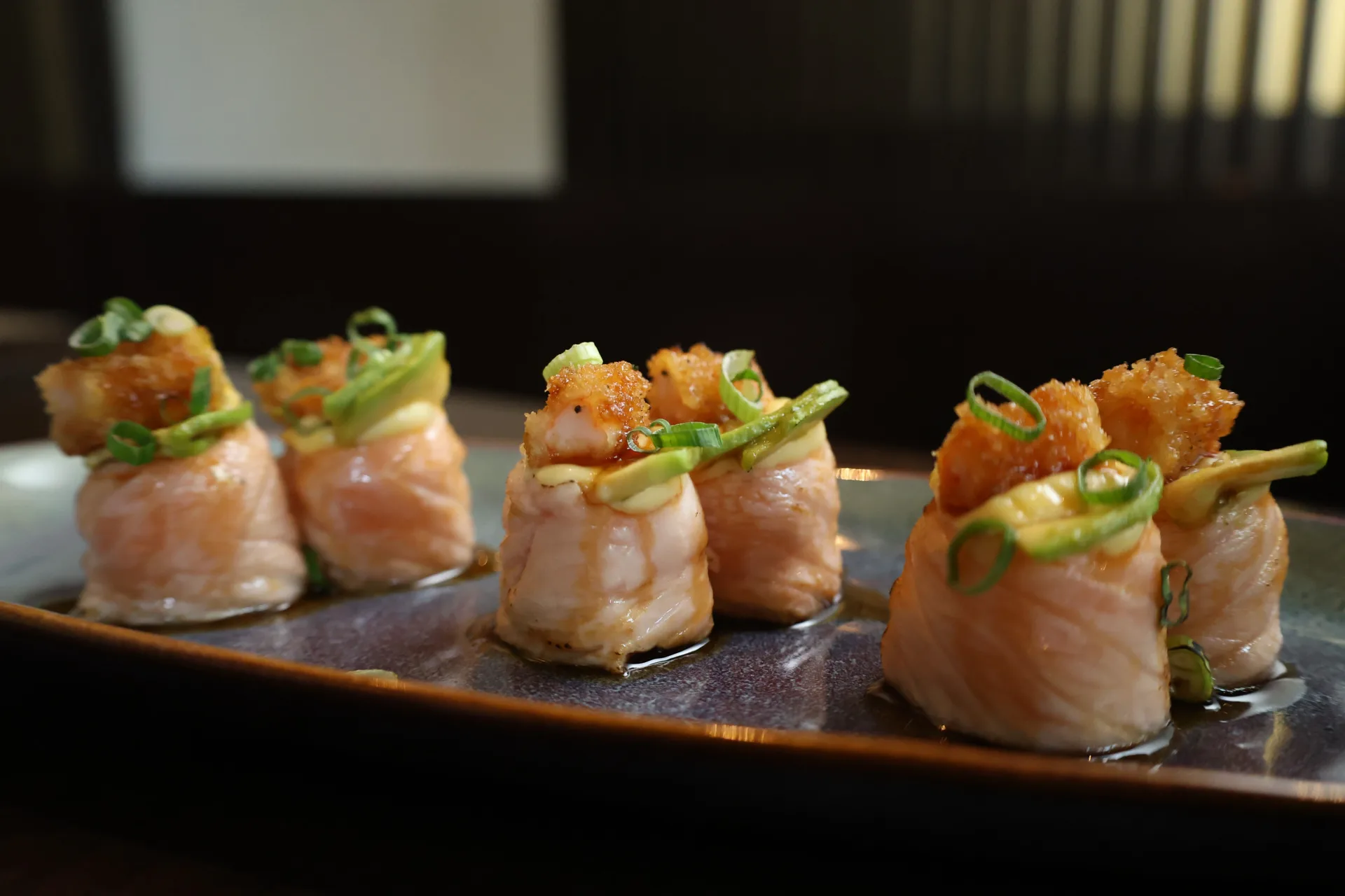 Seared salmon rolls with avocado and crispy topping at Koko