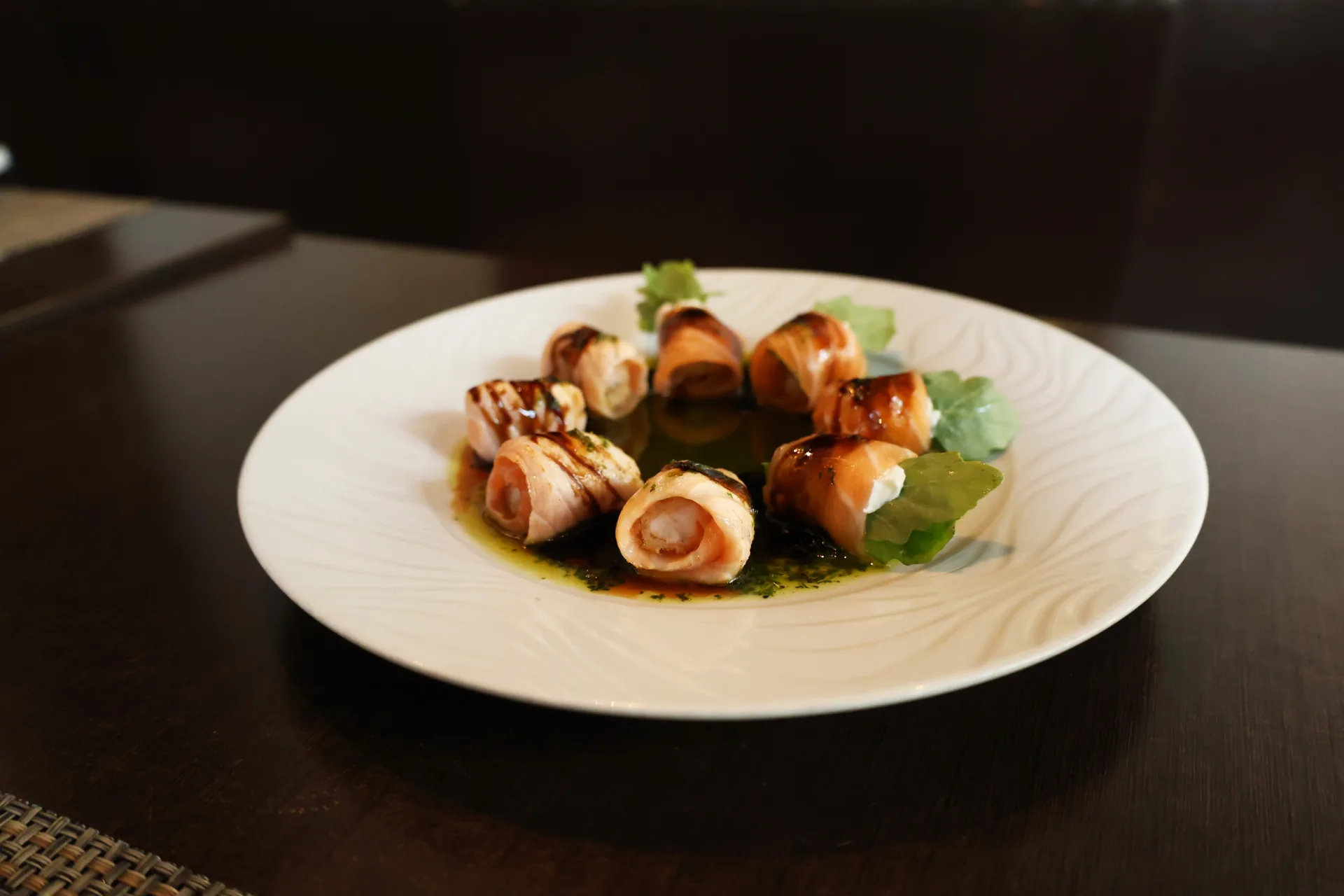 Salmon-wrapped sushi bites served with greens at Koko