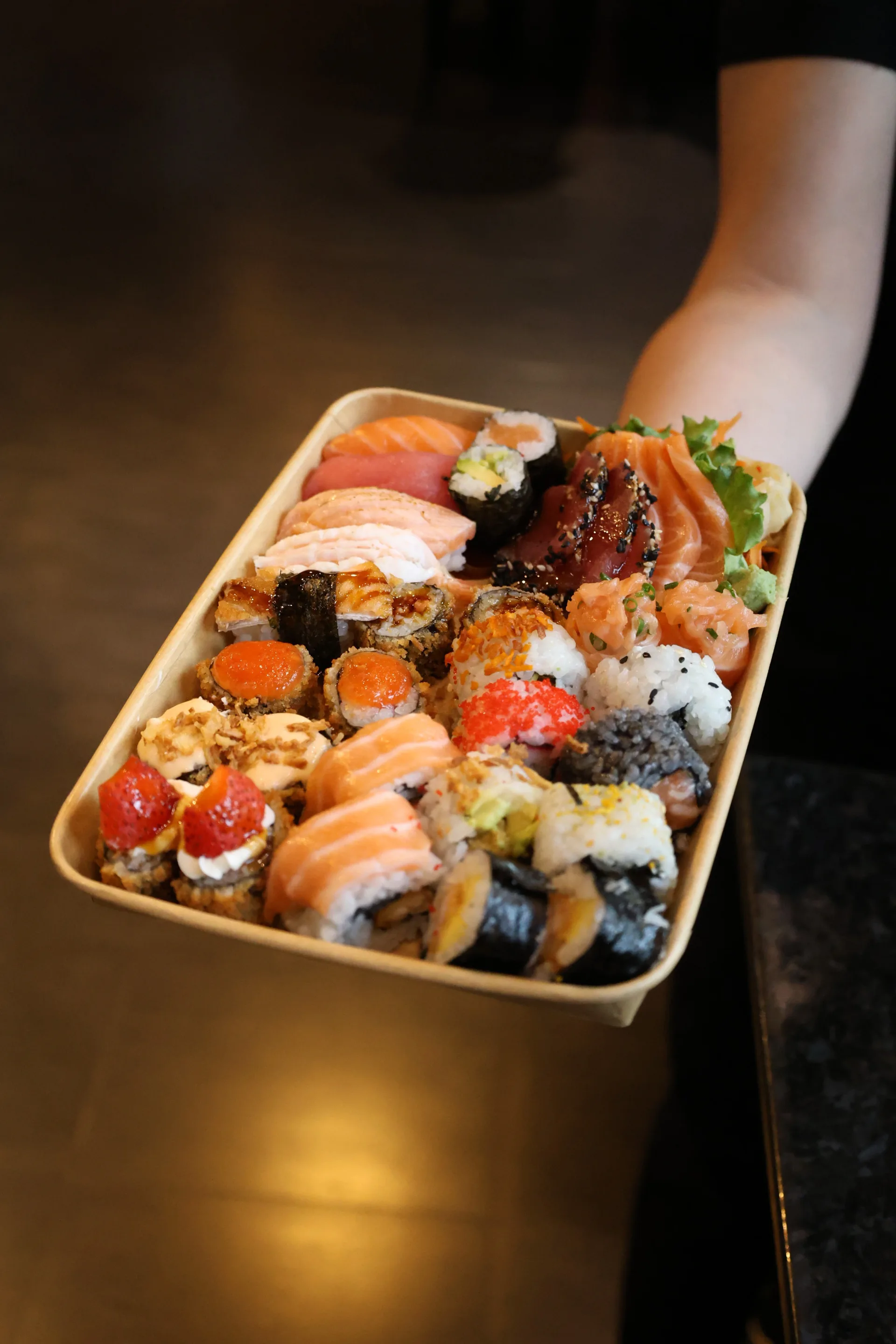 Large sharing tray filled with sashimi, nigiri, and sushi rolls at Koko